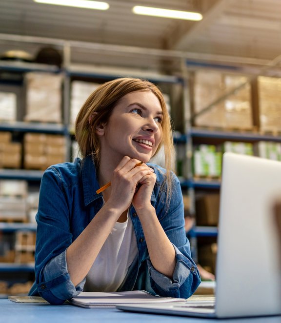 Vrouw werkt op haar laptop in een sorteercentrum